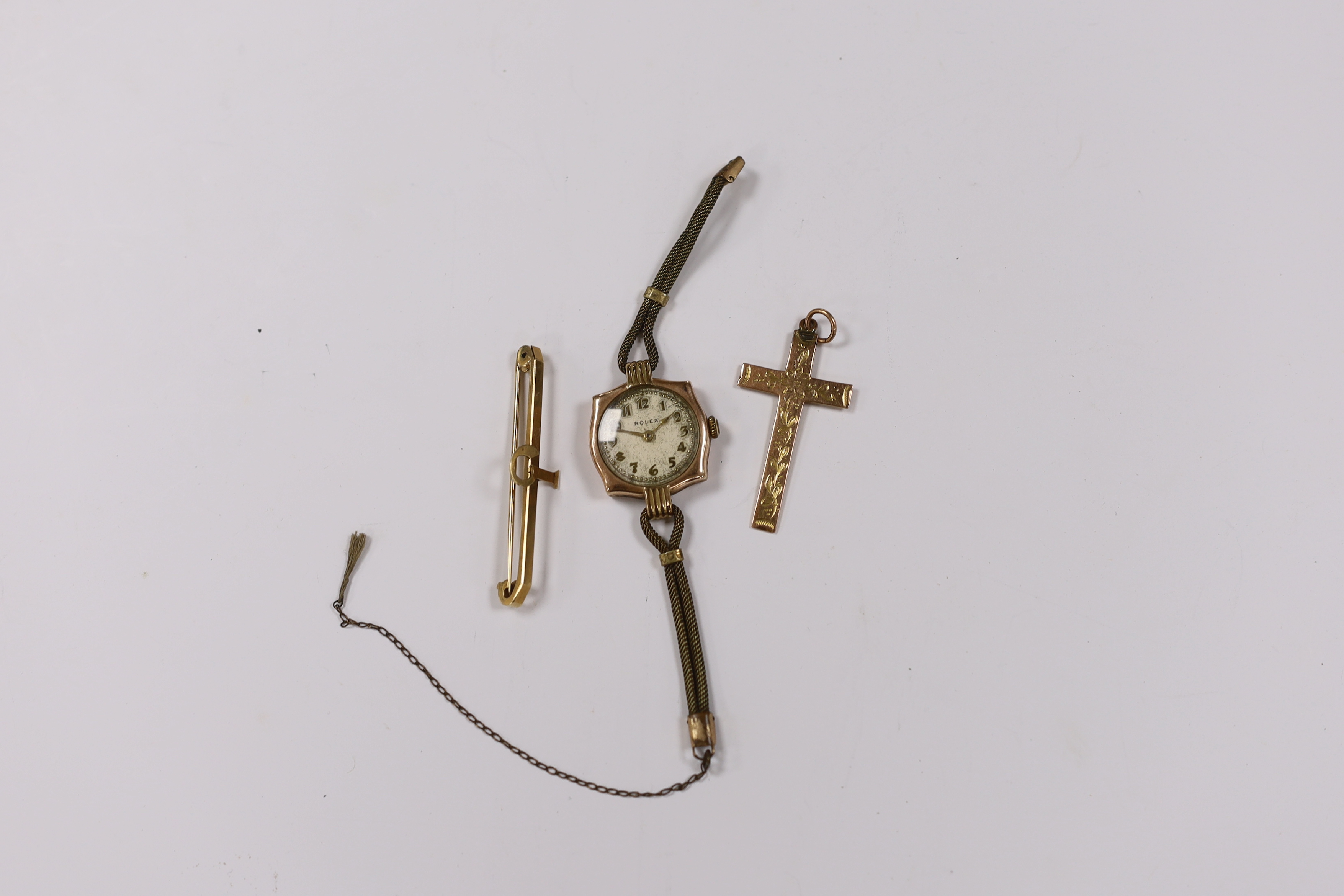 A lady's yellow metal manual wind wrist watch, the dial inscribed 'Rolex', a 9ct gold cross pendant and a 9ct bar brooch.
